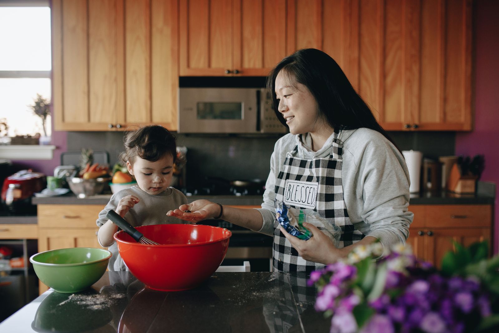 A mother and daughter baking together in their home kitchen